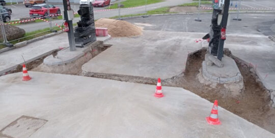 Travaux de rénovation dans une station-service avec des pompes à essence en cours de réparation.