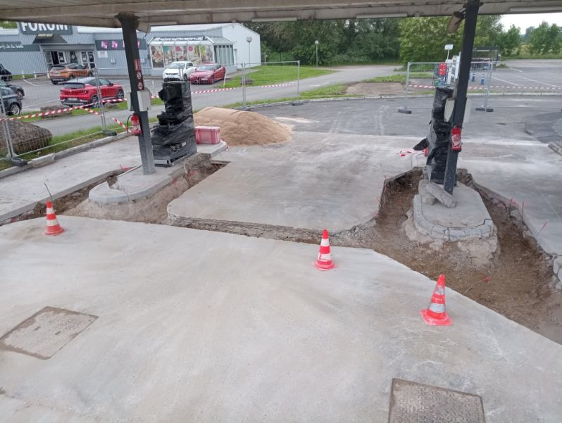 Travaux de rénovation dans une station-service avec des pompes à essence en cours de réparation.
